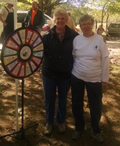 Bobbie Breazeale, Humane Society, shows Shirley Grant of Batesville, the Wheel of prizes.