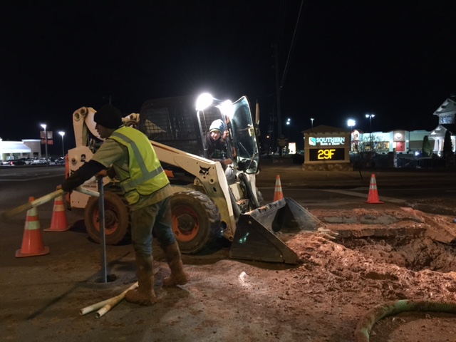 A crew member works as the bank sign behind him flashes the temp. Clarkesville and Demorest Public Works crews spent hours out in the cold repairing water lines that burst due to the cold.