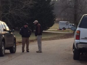 Officers guard the crime scene as GBI investigators search for evidence inside.
