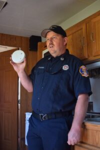 Lt. Chad Keener, explains to the guests in the house simulator that it is important to have a smoke detector.