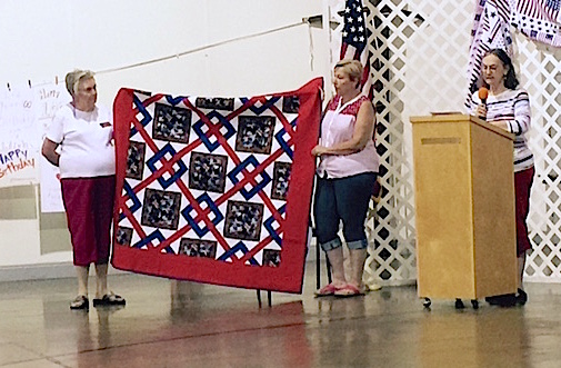 Members of the Quilt of Valor Foundation show the quilt donated to World War 2 veteran Comer Rudeseal on his birthday.