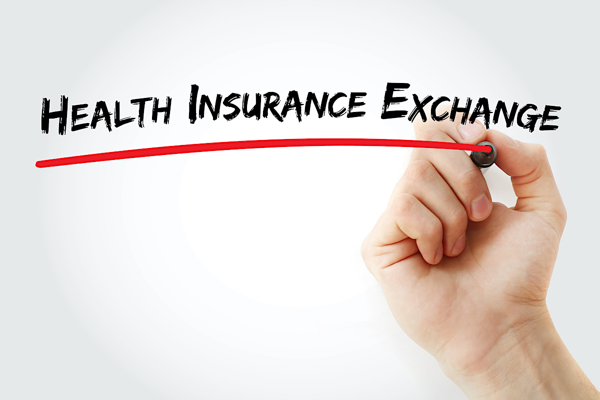Hand writing Health Insurance Exchange with marker, concept background