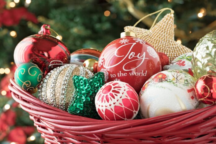 Christmas photograph of Christmas tree ornaments in a basket by the tree