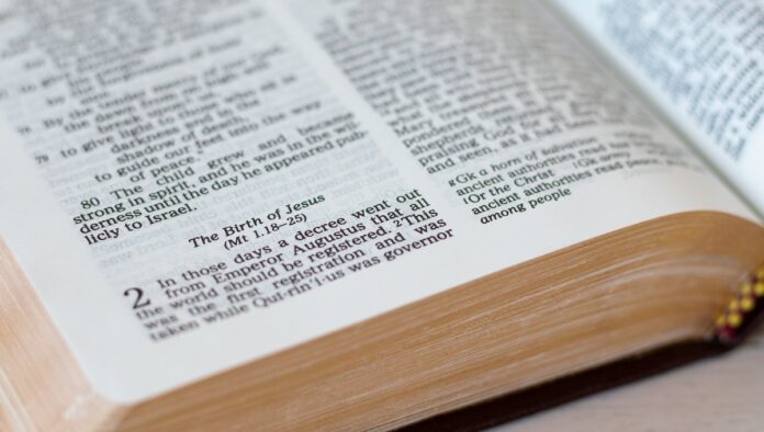 The birth of Jesus Christ, biblical verses in an open Holy Bible Book with golden pages. A closeup. New testament gospel of Luke 2 chapter. Christian biblical concepts of forgiveness, salvation, hope.