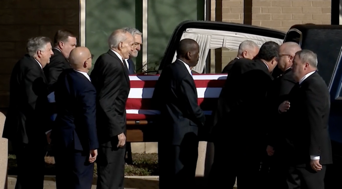 pallbearers place Carter's body in the hearse